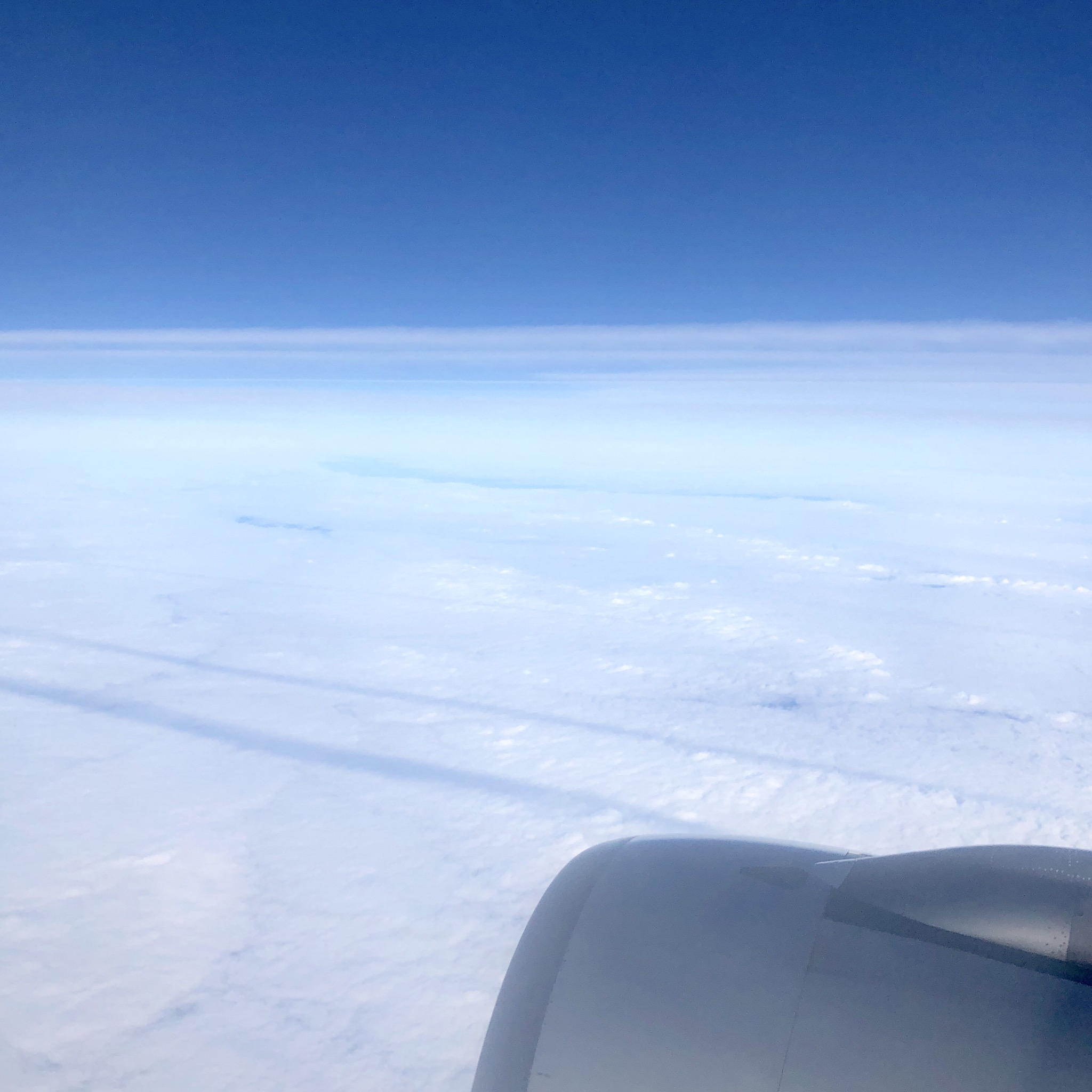 Schatten von Kondensstreifen auf der Wolkendecke